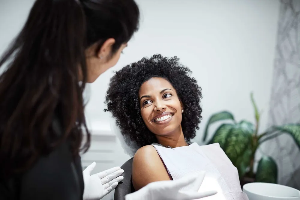 A relaxed patient smiling up at her dentist during a comfort-focused visit.